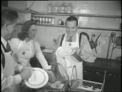 Bob Hope and Dinah Shore help dry dishes at a canteen. News Clip