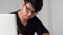 HD DOLLY :  Asian man working on table Stock Footage