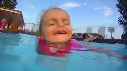 Young girl learns to swim in swimming pool Stock Footage