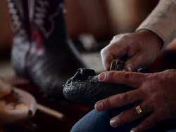 CU TD TU boot maker using tool to stretch leather and place tacks in sole of cowboy boot Stock Footage
