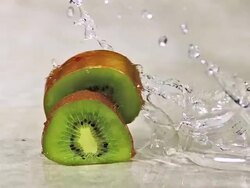 CU SLO MO Shot of Kiwi Fruits, actinidia chinensis, Slice rolling on Water and splashing / Calvados, Normandy, France Stock Footage