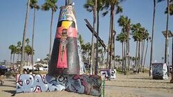 Graffiti covers the Public Art Walls, surrounded by palm trees, near the beach at the Pacific Ocean in Venice, California Stock Footage