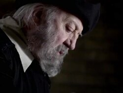 Nostradamus stands up from a table while reading a book. Stock Footage