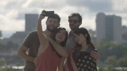 Group of friends pose for selfies with American flag overlooking downtown Austin, Texas Stock Footage