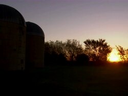 CU of the sunrise at sugar beet plant, with silos in foreground. Stock Footage