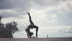 Young woman doing yoga meditating outdoors on a rooftop at sunset Stock Footage