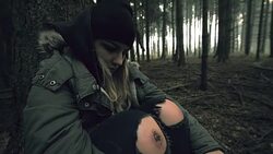Despaired young woman sitting in the forest Stock Footage