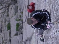 MS R/F SLO MO Shot of male climber with man placing camalot in crack for protection person below holding rope / Estes Park, Colorado, United States Stock Footage
