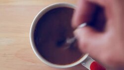 Close view from the top of the coffee is poured into a cup of coffee. Stock Footage