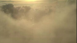 Clouds drift above green fields far below. Stock Footage
