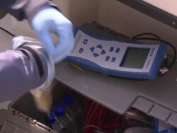 Maintenance workers prepare water testing equipment as they stand in a boat. Stock Footage