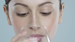 Extreme close-up of young woman with glowing skin drinking a glass of water Stock Footage