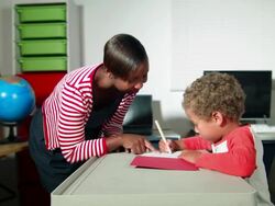 HD: African American Teacher Helping Biracial Boy at School Stock Footage