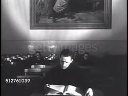 1940: PONTIFICAL GREGORIAN UNIVERSITY: DOCTORIAL CANDIDATE: Seminary student taking oral test for degree, reading from book, dissertation. VS Priests at long table listening. watching intently. Instructional Video