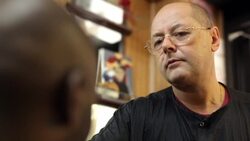 Barber shaves man's head with electric clippers and turns him in his chair in neighborhood barbershop Stock Footage