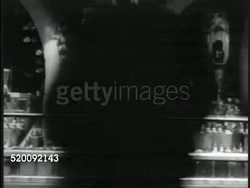 1935: MOSCOW, USSR, SOVIET UNION: People walking past large display window of goods. Shop window display w/ guitar, record player, other luxury  goods. REVERSE SHOT People looking in shop window. Russia, Communism, improved conditions, propaganda. Instructional Video