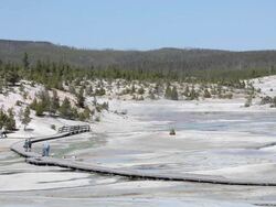 tourists walking amongst geysers in Yellowstone Stock Footage