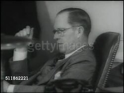 1937: MARITIME COMMISSION: Businessman Joseph Kennedy sitting at desk w/ reporters, journalists standing SOT saying only two reasons to have Merchant Marines...uninterrupted delivery...auxiliary to US Armed Forces. Instructional Video