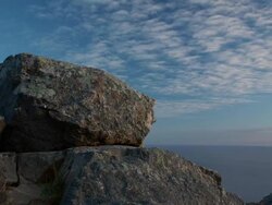 WS T/L Clouds move across blue sky, rocks in foreground, ocean in the distance / Big Sur, California, United States Stock Footage