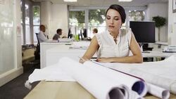 Businesswoman examining blueprints in office Stock Footage