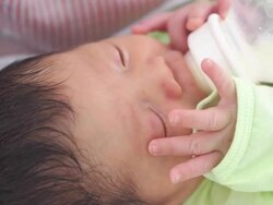 Baby infant suckling milk from bottle Stock Footage