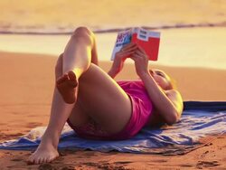 Young girl lying on tropical beach reading book Stock Footage