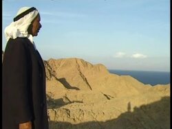 MS Bedouin man standing on dune looking out to sea, side view, Egypt Stock Footage