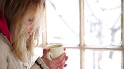Woman having a tea or coffee on snowy day. Stock Footage