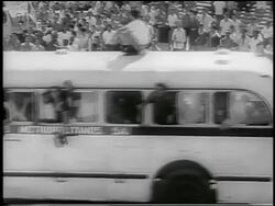 B/W 1959 high angle crowded bus passing camera on street / crowd in background / celebration in Havana / newsreel Stock Footage