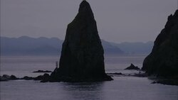 Pinnacle-like rock formations characterize a rugged coastline. Stock Footage