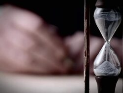 A hand writes near an hourglass. Stock Footage