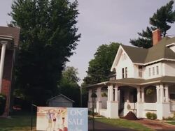 Drive by older homes with front porches on a residential street Stock Footage