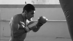 Boxer training in gym with punching bag Stock Footage
