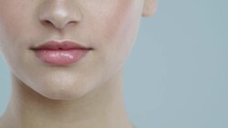 Extreme close-up of young woman with glowing skin taking a vitamin pill and smiling Stock Footage