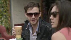 Young man sips coffee and laughs with friends at outdoor caf_ Stock Footage