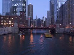 Medium Long Shot static - Tour boats pass beneath a bridge in downtown Chicago, Illinois. / Chicago, Illinois, USA Stock Footage