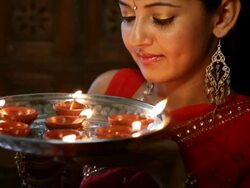 CU TU Portrait of young woman holding tray with lit oil lamps / Singapore Stock Footage