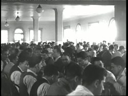 Immigrants eat in a large cafeteria on Ellis Island. News Clip