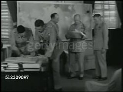 1942: U.S. MARINE CORPS HEADQUARTERS: CU Sign. INT MS First Lieutenant General Thomas J. Holden (unconfirmed) talking w/ officers in office. CU Holden standing w/ papers, talking. MS Holden & officials looking at wall map. Washington D.C. WWII Instructional Video