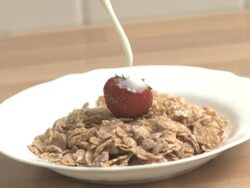 Milk pours in bowl of corn flakes cereal Stock Footage