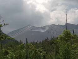 Wide shot of crater of Sakurajima volcano with scrub land in foreground, Japan Stock Footage