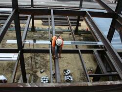 A steelworker walks across a narrow steel beam Stock Footage