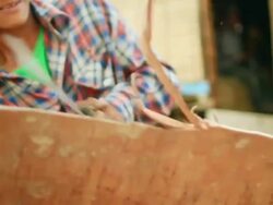 MS POV SLO MO Shot of villager hacking at wooden board with machete / Muang Ngoi, Luang Prabang, Laos Stock Footage