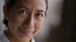 Female chef looks up and smiles at camera Stock Footage