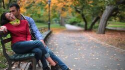 New York couple in love nuzzle on park-bench in Central Park (dolly-shot) Stock Footage