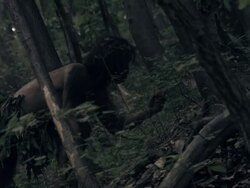 Prehistoric man in the forest eating fruit. Stock Footage