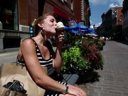 MS Lady with shopping bags licking maple syrup flavored ice cream cone in old montreal in hot summer day / Montreal, Quebec, Canada Stock Footage