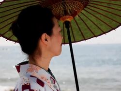Japanese woman with a parasol enjoying sea Stock Footage