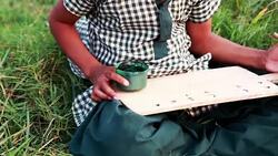 Little Girl Sitting in the Field and Studying Outdoor Portrait Stock Footage