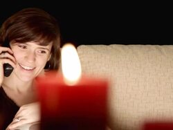 Woman talks on phone by candlelight Stock Footage